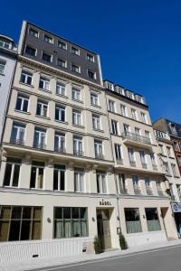 a large white building with windows on a street at Babel Lille Centre in Lille