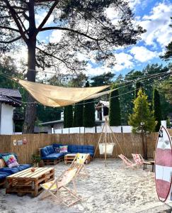 a patio with a hammock and a couch and chairs at Kompleks Detlafówka in Dębki