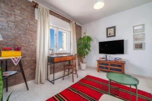 a living room with a television and a table and chair at See view Mignon de la Ria Formosa in Faro