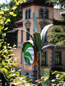 a sign in front of a building with a palm tree at Apart Hotel Stadtgarten in Überlingen