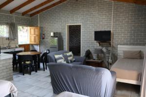 a living room with a bed and a kitchen at Numbi Hills Self-Catering in Hazyview