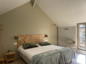 a bedroom with a bed with two pillows on it at Les Thibériades in Martin-Église +1 photo
