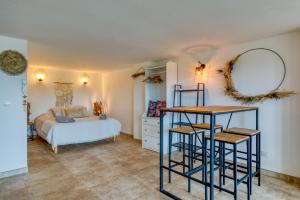 a bedroom with a bed and a table and a mirror at Mas Des Jeux - Gîte Grenache in Saint-Laurent-dʼAigouze
