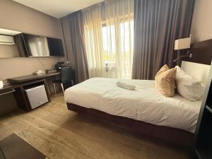 a bedroom with a bed and a desk and a window at Hotel SKØL in Strassen