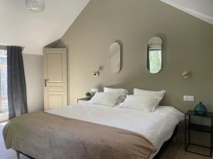 a bedroom with a large white bed with white pillows at Les Thibériades in Martin-Église