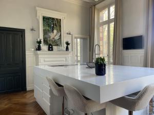 a kitchen with a large white island with chairs at Les Thibériades in Martin-Église