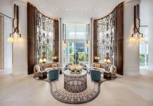 a lobby with a table and chairs and windows at Waldorf Astoria Bangkok in Bangkok