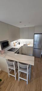 a kitchen with a white counter and two chairs at Modern Executive Studio in Gibraltar