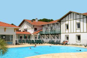 a pool in front of a building with people in it at Oly Vacances Les Landes in Cassen