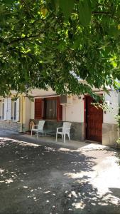 a house with two chairs and a bench in front of it at Katy's Home in Próti