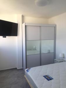 a bedroom with a bed with a sliding glass door at Dizengoff 24A in Netanya