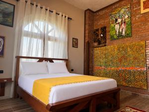 a bedroom with a bed and a painting on the wall at Vila Shehi Guesthouse and Winery in Tirana