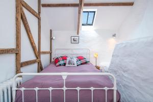 a bedroom with a white bed with a purple blanket at Melin Abereiddy in Haverfordwest
