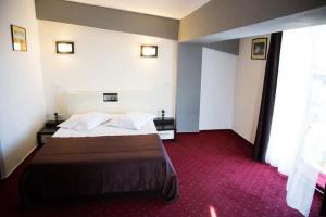 a hotel room with a bed and a red carpet at GP Hotel StarCity in Tătărani