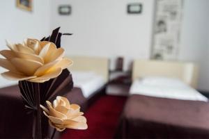 a vase with flowers on a table in a room at GP Hotel StarCity in Tătărani