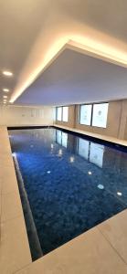 a large swimming pool with blue water in a building at Modern Executive Studio in Gibraltar