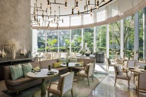 a restaurant with tables and chairs and a chandelier at Waldorf Astoria Bangkok in Bangkok +124 photos
