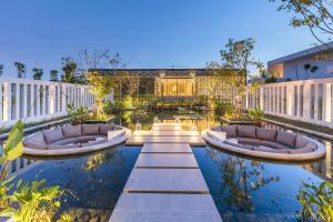 a garden with two chairs and a pool at Meliá Phuket Mai Khao in Mai Khao Beach