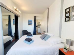 a bedroom with a large white bed and a chair at Notre bout du monde t1bis brest centre terrasse in Brest