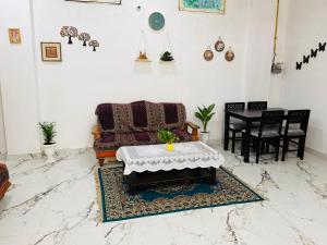 a living room with a table and a couch at Sadhana kunj in Varanasi