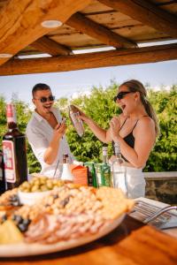 a man and woman standing at a table with a plate of food at Lika Story in Josipdol