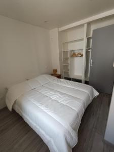 a bedroom with a large white bed in it at Le Nid d'Ouilly in Pont-d'Ouilly +18 photos