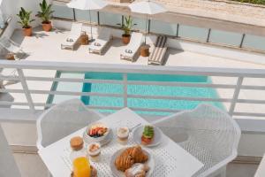 a table with food on a balcony with a pool at Bauló Mar Apartments in Can Picafort
