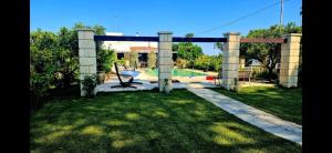 a garden with a pergola and a swimming pool at Villa Kepos in Arnesano +2 photos