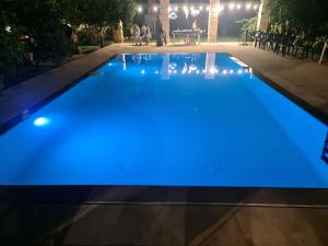 a swimming pool lit up blue at night at Villa Kepos in Arnesano