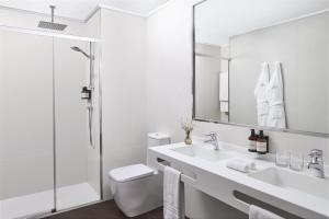 a white bathroom with a sink and a shower at NH Collection Vigo in Vigo
