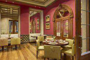 a restaurant with pink walls and tables and chairs at NH Collection Vigo in Vigo +30 photos