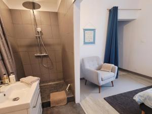 a bathroom with a shower and a chair and a sink at Notre bout du monde t1bis brest centre terrasse in Brest +5 photos