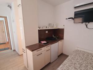 a small kitchen with white cabinets and a sink at Apartments Pr' Štormanu in Kanal