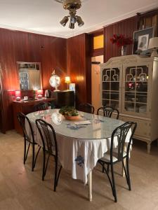 a dining room with a table with chairs and a cabinet at Guest House Vila Eli in Herceg-Novi