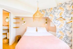 a bedroom with a bed and a colorful wall at Appart'Hôtel & Spa "Les Voiles" Le Molène in Carnac