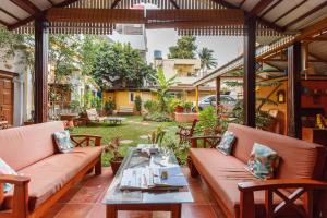 eine Terrasse mit Sofas und einem Tisch auf der Terrasse in der Unterkunft Casa Cottage in Bangalore