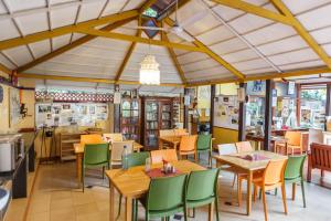 a restaurant with wooden tables and green chairs at Casa Cottage in Bangalore