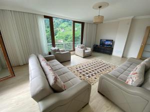 a living room with two couches and a television at Komilo Homes - Functional Modern Suite in Çamlıhemşin
