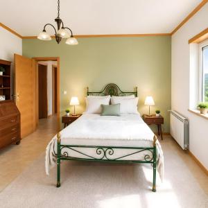 a bedroom with a bed and two lamps and a window at Caramulo Valley View in Campo de Besteiros