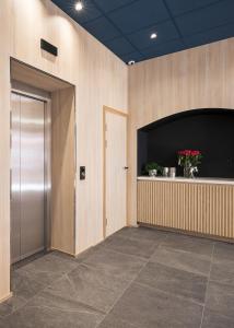 eine Lobby mit einem großen Bildschirmfernseher und einer Tür in der Unterkunft NEW JULY 2026! BREEZE Bergen City - Self Service in Bergen