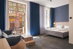 ein Schlafzimmer mit einem Bett, einer Couch und einem Fenster in der Unterkunft NEW JULY 2026! BREEZE Bergen City - Self Service in Bergen + 56 Fotos