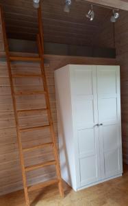 a room with a ladder and a white cabinet at FeWo Wardersee in Rohlsdorf