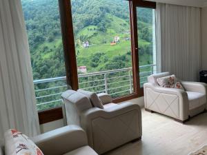 a room with two chairs and a large window at Komilo Homes - Functional Modern Suite in Çamlıhemşin