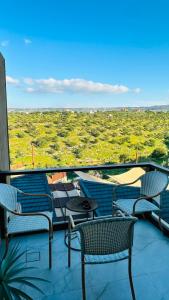 a balcony with chairs and tables and a view at Pilar Resort in Bayyūḑah