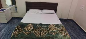 a bed in a small room with a white bedspread at Shree Ganesh lodging in Bārkūr