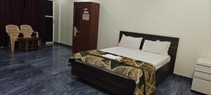 a bedroom with a bed and a dresser and chairs at Shree Ganesh lodging in Bārkūr