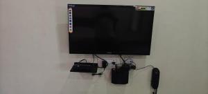 a flat screen tv hanging on a white wall at Shree Ganesh lodging in Bārkūr