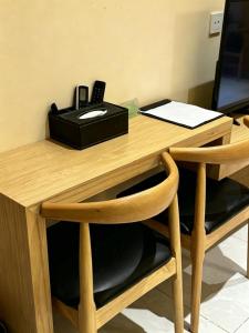 a wooden desk with a phone on top of it at zhiyuanta hotel in Vientiane +3 photos