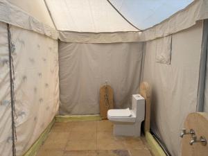 a bathroom with a toilet in a tent at Style Heritage Resort & Camp in Sām