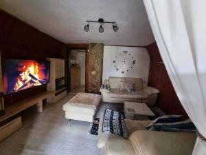 a living room with a couch and a flat screen tv at Enjoy the Silence Holiday Home in Vlasic
